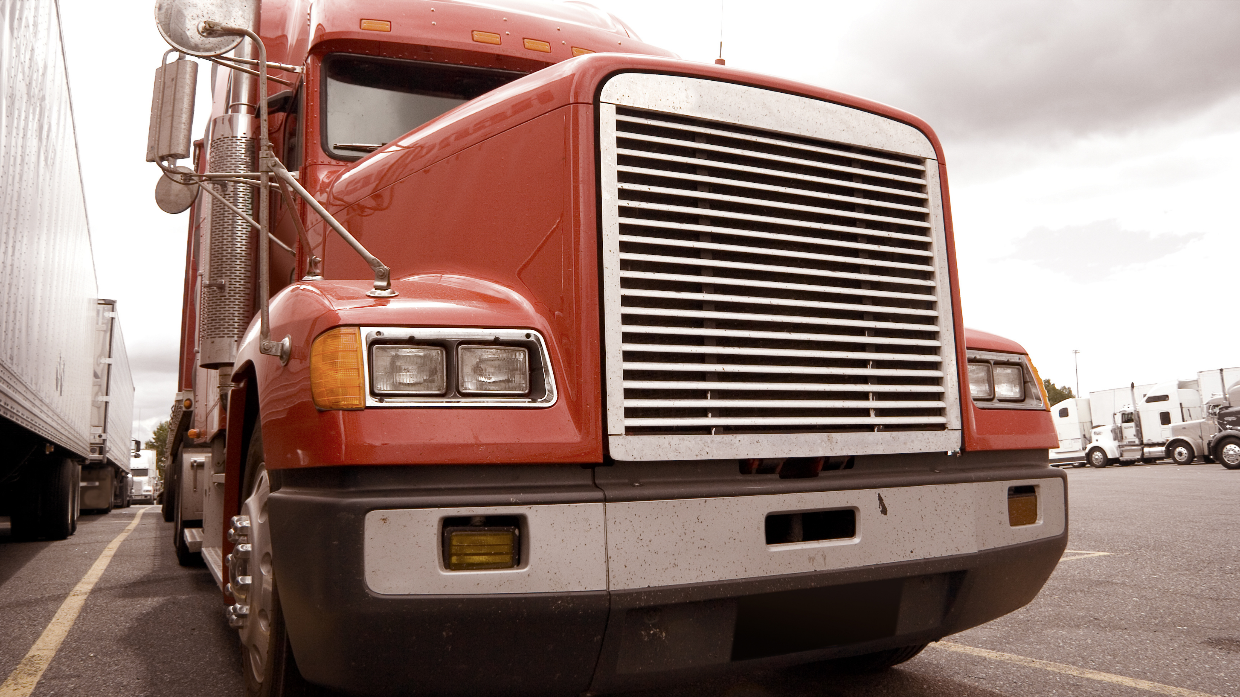 truck maintenance is important for trucks like the pictured red front and large grill of a semi-truck