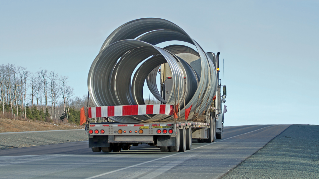 heavy hauling truck maintenance is needed for the pictured large truck with metal rings on desolate highway
